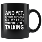 And Yet Despite The look On My Face You're Still Talking Black coffee mug