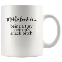 Motherhood is being a tiny person’s snack bitch white coffee mug